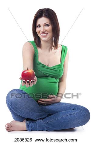A pregnant woman holding out an apple; edmonton alberta canada View Large Photo Image Stock Photograph - A pregnant woman holding out an apple; edmonton alberta canada. Fotosearch