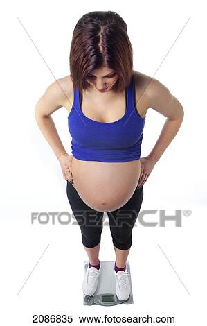 A pregnant woman stands on a scale; edmonton alberta canada View Large Photo Image Stock Photography - A pregnant woman stands on a scale; edmonton alberta canada. Fotosearch