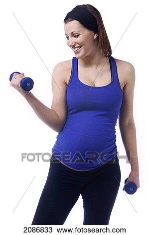 Stock Image - A pregnant woman uses dumbbells for fitness; edmonton alberta canada. Fotosearch