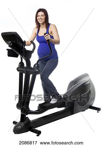 A pregnant woman using fitness equipment; edmonton alberta canada View Large Photo Image Stock Photo - A pregnant woman using fitness equipment; edmonton alberta canada. Fotosearch
