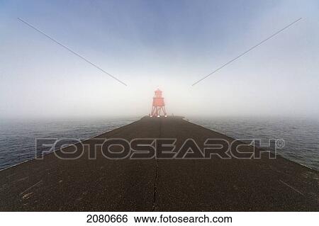 A red lighthouse at the end of a concrete pier looking out to the fog over the ocean; south shields tyne and wear england View Large Photo Image Stock Photograph - A red lighthouse at the end of a concrete pier looking out to the fog over the ocean; south shields tyne and wear england. Fotosearch