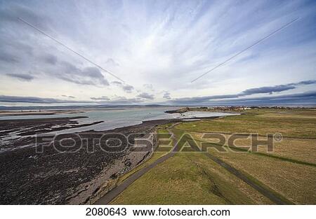 Stock Image - A road running along the coast; lindisfarne northumberland england. Fotosearch