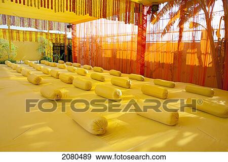 A room decorated with yellow rolled cushions and silhouette of palm trees showing through the sheer curtains around the outside of the room; ludhiana punjab india View Large Photo Image Stock Photo - A room decorated with yellow rolled cushions and silhouette of palm trees showing through the sheer curtains around the outside of the room; ludhiana punjab india. Fotosearch