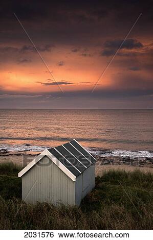 A Small Building Along The Water With A Pink Sky At Sunset; Bamburgh Northumberland England View Large Photo Image Stock Photograph - A Small Building Along The Water With A Pink Sky At Sunset; Bamburgh Northumberland England. Fotosearch