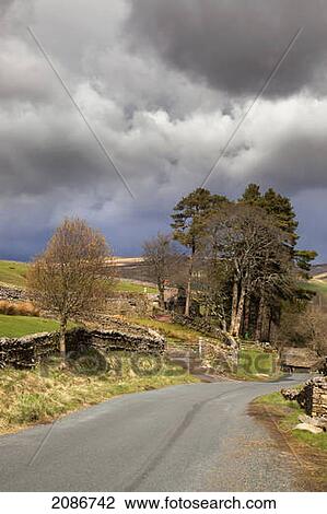 A stone fence along a road under storm clouds; swaledale england View Large Photo Image Stock Image - A stone fence along a road under storm clouds; swaledale england. Fotosearch