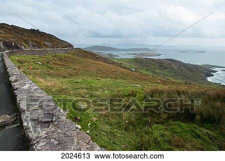Stock Image - A Stone Wall Along A Road Traveling Along The Coastline; Ireland. Fotosearch