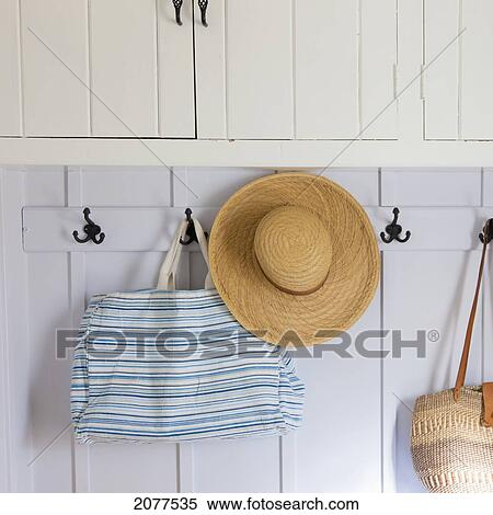 A straw hat and bags hanging on hooks; pigeon lake alberta canada View Large Photo Image Stock Photography - A straw hat and bags hanging on hooks; pigeon lake alberta canada. Fotosearch