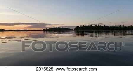 Stock Photo - A tranquil lake at sunset; lake of the woods ontario canada. Fotosearch