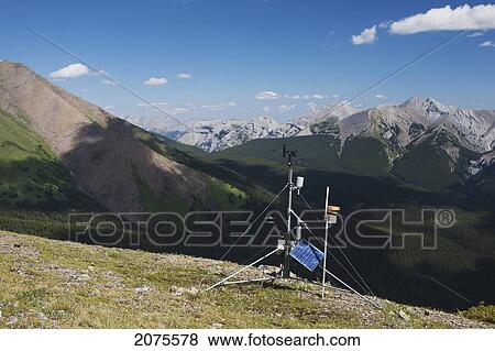 Stock Photo - A Weather Station On Top Of A Ridge With Mountains And Valley In The Distance And Blue Sky With Clouds; Alberta Canada. Fotosearch