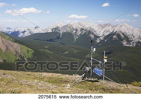 A Weather Station On Top Of A Ridge With Mountains And Valley In The Distance And Blue Sky With Clouds; Alberta Canada View Large Photo Image Stock Photography - A Weather Station On Top Of A Ridge With Mountains And Valley In The Distance And Blue Sky With Clouds; Alberta Canada. Fotosearch