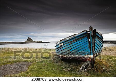 A Weathered Boat Sitting On The Shore With Lindisfarne Castle In The Distance; Lindisfarne Northumberland England View Large Photo Image Stock Image - A Weathered Boat Sitting On The Shore With Lindisfarne Castle In The Distance; Lindisfarne Northumberland England. Fotosearch