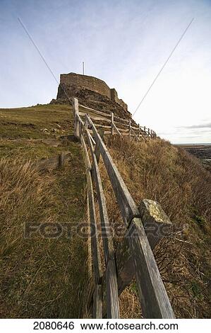 A weathered wooden fence along the water's edge with a building in the background; lindisfarne northumberland england View Large Photo Image Stock Photograph - A weathered wooden fence along the water's edge with a building in the background; lindisfarne northumberland england. Fotosearch