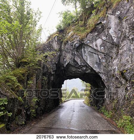 A wet road leading through a tunnel in a rock cliff; bergen norway View Large Photo Image Stock Image - A wet road leading through a tunnel in a rock cliff; bergen norway. Fotosearch
