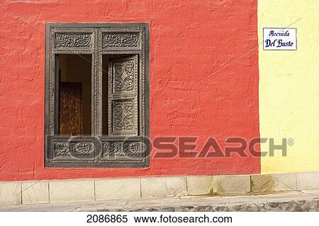 Stock Photography - A window with ornate gold trim and shutters on a building painted red and yellow; lima peru. Fotosearch
