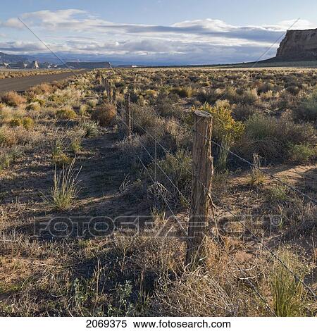 Stock Photography - A Wire Fence And Road Through Glen Canyon National Recreation Area; Utah United States Of America. Fotosearch