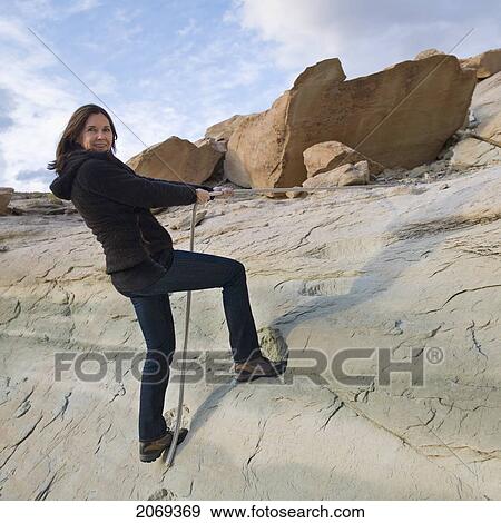 A Woman Climbs A Rock Cliff; Utah United States Of America View Large Photo Image Stock Photo - A Woman Climbs A Rock Cliff; Utah United States Of America. Fotosearch
