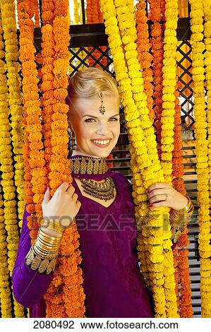 A woman dressed in a purple sari holding onto the hanging strung flowers; ludhiana punjab india View Large Photo Image Stock Image - A woman dressed in a purple sari holding onto the hanging strung flowers; ludhiana punjab india. Fotosearch