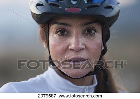 Stock Photo - A woman in a bicycle helmet dripping with sweat; tarifa cadiz andalusia spain. Fotosearch