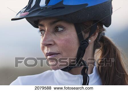 Stock Photo - A woman in a bicycle helmet dripping with sweat; tarifa cadiz andalusia spain. Fotosearch