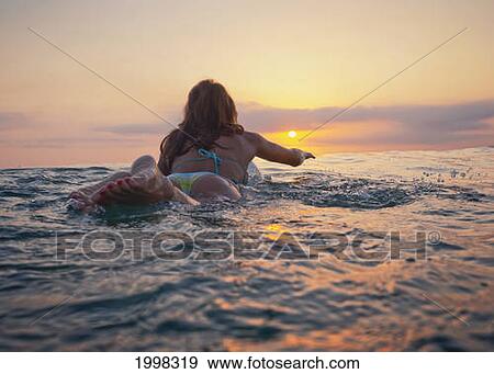 A Woman Laying On A Surfboard Watching The Sunset; Tarifa Cadiz Andalusia Spain View Large Photo Image Stock Photo - A Woman Laying On A Surfboard Watching The Sunset; Tarifa Cadiz Andalusia Spain. Fotosearch