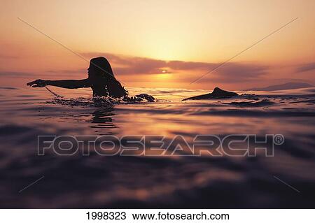 A Woman Paddling On A Surfboard At Sunset; Tarifa Cadiz Andalusia Spain View Large Photo Image Stock Image - A Woman Paddling On A Surfboard At Sunset; Tarifa Cadiz Andalusia Spain. Fotosearch