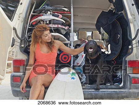 A Woman Sits In The Back Of A Vehicle With A Surfboard And Petting A Dog; Tarifa Cadiz Andalusia Spain View Large Photo Image Stock Photograph - A Woman Sits In The Back Of A Vehicle With A Surfboard And Petting A Dog; Tarifa Cadiz Andalusia Spain. Fotosearch