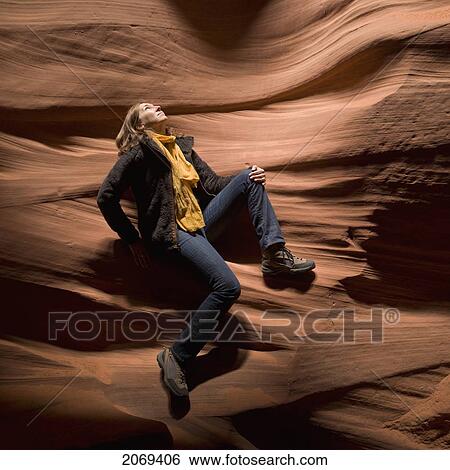 A Woman Sits On A Sandstone Wall Looking Upwards At An Opening To The Sunlight; Arizona United States Of America View Large Photo Image Stock Photograph - A Woman Sits On A Sandstone Wall Looking Upwards At An Opening To The Sunlight; Arizona United States Of America. Fotosearch