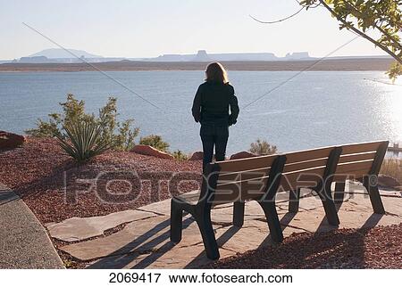 A Woman Stands By A Bench Looking Out Over Lake Powell; Arizona United States Of America View Large Photo Image Stock Photo - A Woman Stands By A Bench Looking Out Over Lake Powell; Arizona United States Of America. Fotosearch