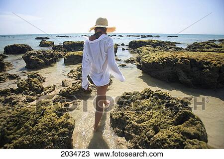 Stock Image - A Woman Tourist Enjoys The Sunshine On The Beach Of A Tropical Island; Koh Lanta Thailand. Fotosearch