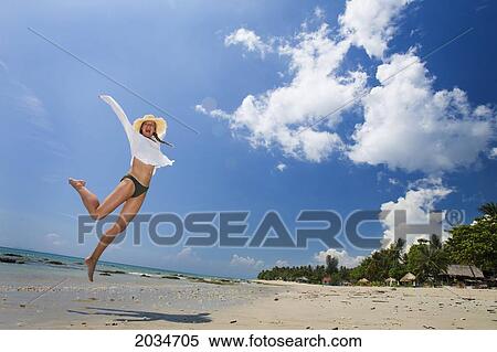 A Woman Tourist Jumps In The Air On The Beach Of A Tropical Island; Koh Lanta Thailand View Large Photo Image Stock Photography - A Woman Tourist Jumps In The Air On The Beach Of A Tropical Island; Koh Lanta Thailand. Fotosearch