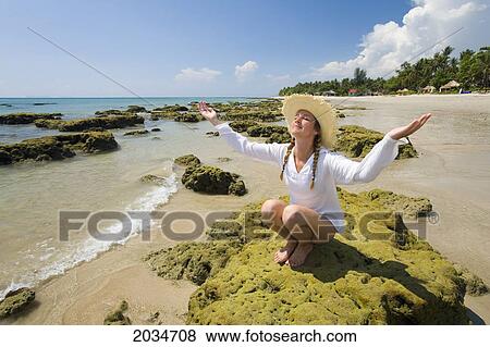 Stock Photo - A Woman Tourist Raises Her Arms On The Beach Of A Tropical Island; Koh Lanta Thailand. Fotosearch