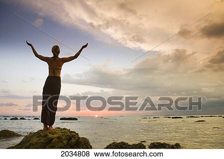 A Woman Tourist Raises Her Arms On The Beach Of A Tropical Island At Sunset; Koh Lanta Thailand View Large Photo Image Stock Photo - A Woman Tourist Raises Her Arms On The Beach Of A Tropical Island At Sunset; Koh Lanta Thailand. Fotosearch
