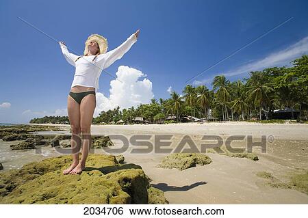 A Woman Tourist Raises Her Arms On The Beach Of A Tropical Island; Koh Lanta Thailand View Large Photo Image Stock Photograph - A Woman Tourist Raises Her Arms On The Beach Of A Tropical Island; Koh Lanta Thailand. Fotosearch