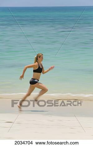 A Woman Tourist Runs Along The Beach On A Tropical Island; Koh Lanta Thailand View Large Photo Image Picture - A Woman Tourist Runs Along The Beach On A Tropical Island; Koh Lanta Thailand. Fotosearch