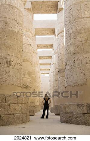 Stock Image - A Woman Tourist Stands At The Base Of The Massive Columns In The Temples Of Karnak On The East Bank Of Luxor Along The Nile River; Egypt. Fotosearch