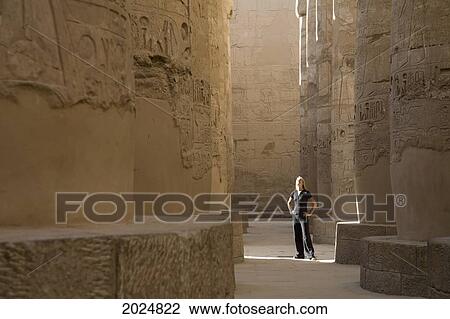 A Woman Tourist Stands At The Base Of The Massive Columns In The Temples Of Karnak On The East Bank Of Luxor Along The Nile River; Egypt View Large Photo Image Stock Image - A Woman Tourist Stands At The Base Of The Massive Columns In The Temples Of Karnak On The East Bank Of Luxor Along The Nile River; Egypt. Fotosearch