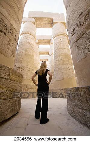 A Woman Tourist Stands At The Base Of The Massive Columns In The Temples Of Karnak On The East Bank Of Luxor Along The Nile River; Luxor Egypt View Large Photo Image Stock Photograph - A Woman Tourist Stands At The Base Of The Massive Columns In The Temples Of Karnak On The East Bank Of Luxor Along The Nile River; Luxor Egypt. Fotosearch