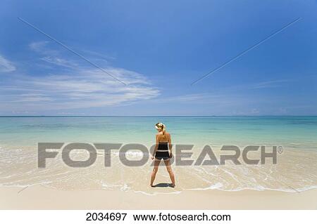 A Woman Tourist Stands In The Shallow Clear Waters Of A Tropical Island; Koh Lanta Thailand View Large Photo Image Stock Photo - A Woman Tourist Stands In The Shallow Clear Waters Of A Tropical Island; Koh Lanta Thailand. Fotosearch