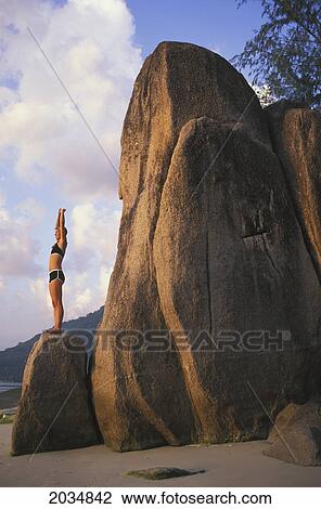 A Woman Tourist Stretches And Does Yoga On A Beach Of A Tropical Island; Koh Tao Thailand View Large Photo Image Stock Image - A Woman Tourist Stretches And Does Yoga On A Beach Of A Tropical Island; Koh Tao Thailand. Fotosearch