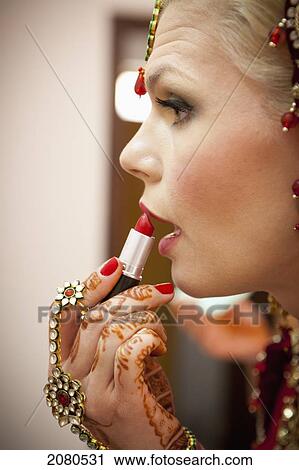 A woman with mehndi jewelry on her hands and applies lipstick; ludhiana punjab india View Large Photo Image Stock Image - A woman with mehndi jewelry on her hands and applies lipstick; ludhiana punjab india. Fotosearch
