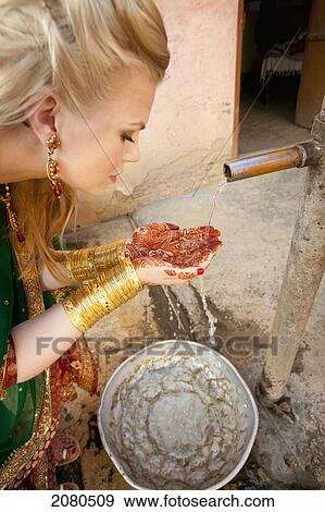 A woman with mehndi on her palms cups her hands to collect water from a tap; ludhiana punjab india View Large Photo Image Stock Photo - A woman with mehndi on her palms cups her hands to collect water from a tap; ludhiana punjab india. Fotosearch