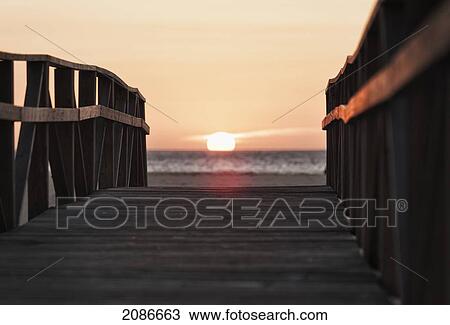 A wooden boardwalk leading to the ocean and beach at sunset; tarifa cadiz andalusia spain View Large Photo Image Stock Image - A wooden boardwalk leading to the ocean and beach at sunset; tarifa cadiz andalusia spain. Fotosearch