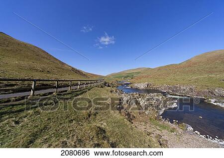A wooden fence along a road with a stream running through the hills; cheviots northumberland england View Large Photo Image Stock Photograph - A wooden fence along a road with a stream running through the hills; cheviots northumberland england. Fotosearch