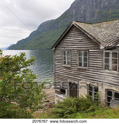 Stock Photo - A wooden house along the water's edge; hardangervidda norway. Fotosearch