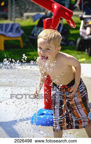 A Young Boy Playing In A Splash Park; Three Hills Alberta Canada View Large Photo Image Stock Photo - A Young Boy Playing In A Splash Park; Three Hills Alberta Canada. Fotosearch