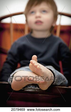 A young boy sitting on a chair with bare feet; bellingham washington united states of america View Large Photo Image Stock Photo - A young boy sitting on a chair with bare feet; bellingham washington united states of america. Fotosearch