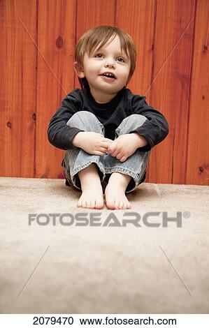 A young boy sitting on the floor with bare feet; bellingham washington united states of america View Large Photo Image Stock Image - A young boy sitting on the floor with bare feet; bellingham washington united states of america. Fotosearch
