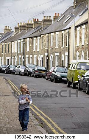 A Young Boy Walks Down The Street With A Stick; Cambridge United Kingdom View Large Photo Image Stock Image - A Young Boy Walks Down The Street With A Stick; Cambridge United Kingdom. Fotosearch