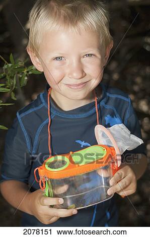 Stock Image - A young boy with a bug catcher; lake tahoe california united states of america. Fotosearch