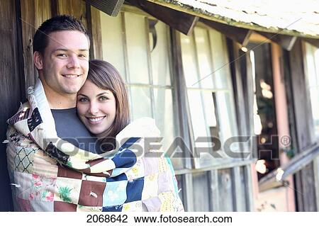 Stock Image - A Young Man And Young Woman Wrapped Together In A Blanket; Troutdale Oregon United States Of America. Fotosearch